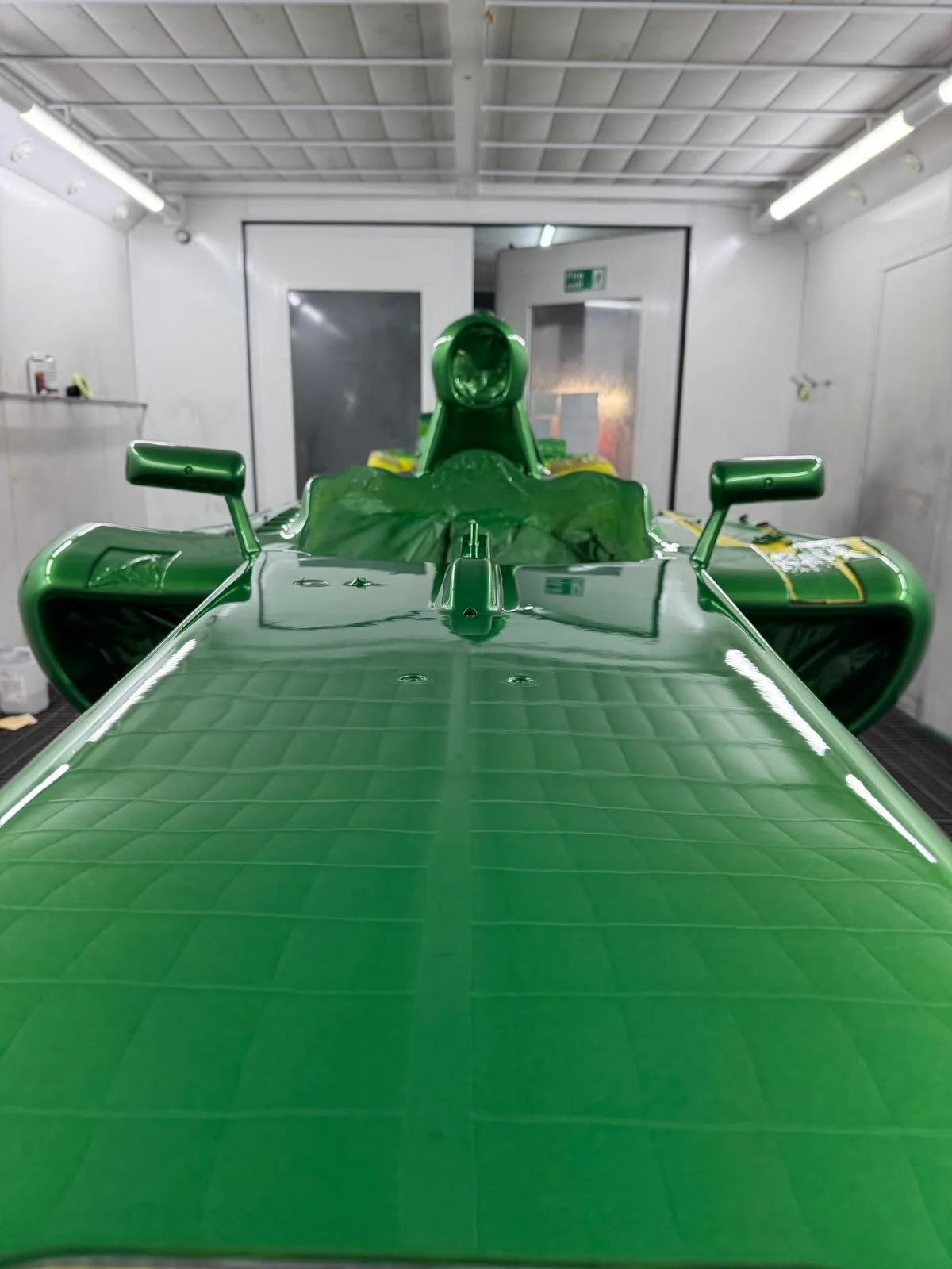 Green race car prepared in the Lusso Auto Care workshop