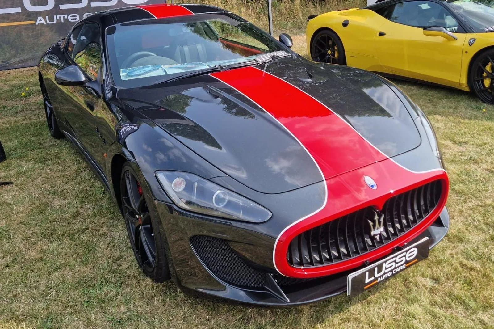 Black and red sports car on display at an automotive event